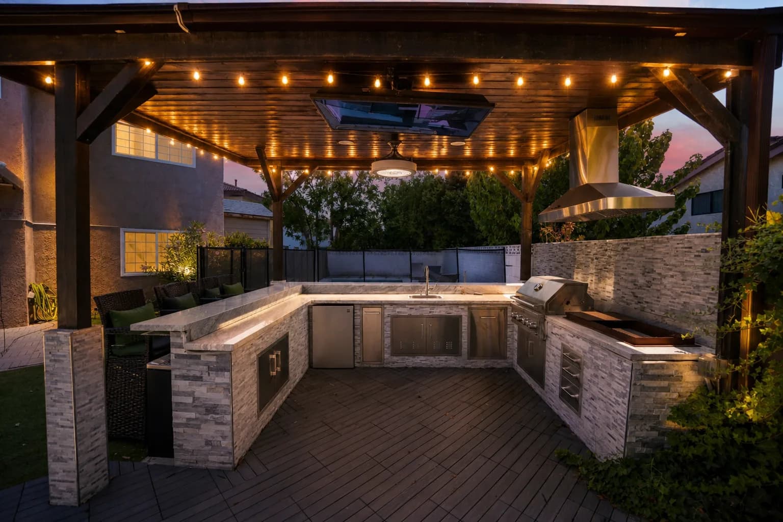 The covered terrace at Providence Detox at night, string lights over the outdoor kitchen.