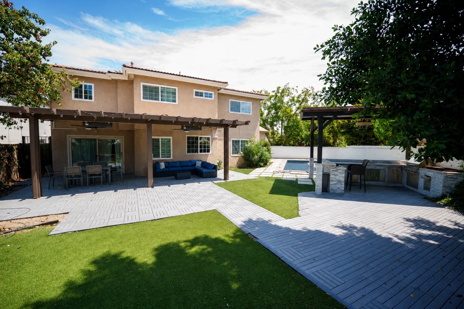Landscaped residence courtyard with shaded seating and an outdoor kitchen.